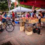 Bikers and Pedestrians at a Farmer's Market